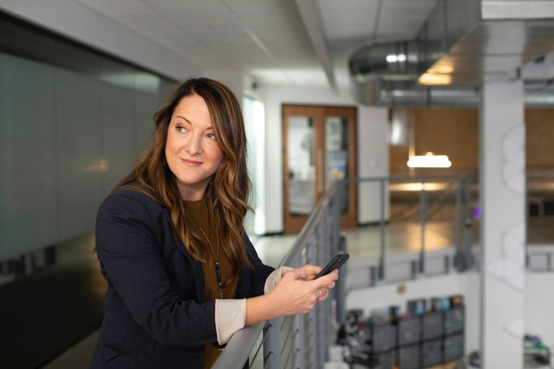 A woman in a business suit stands in an office lobby.